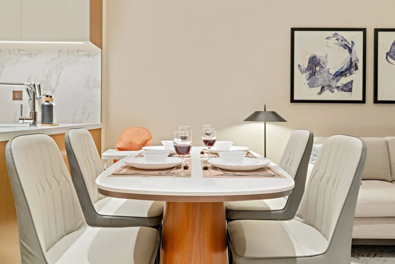 A dining area with a table set beneath framed artwork.