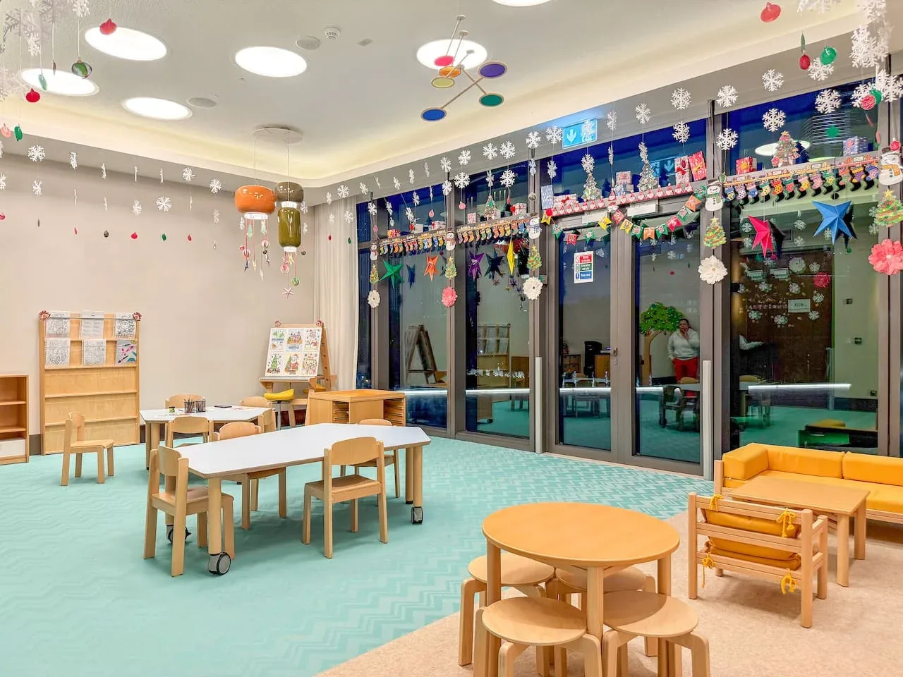 A brightly decorated classroom with small tables and seating.