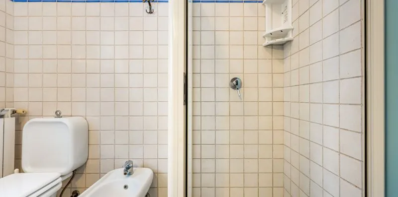 A tiled bathroom with a shower and sink.