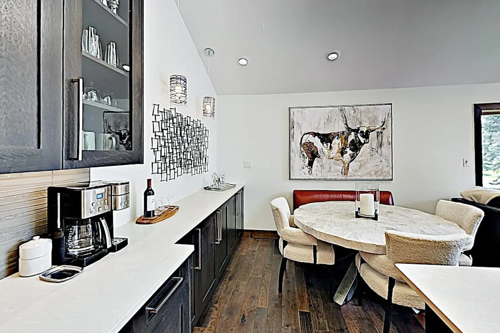 A dining area with a round table and a long counter along the wall.