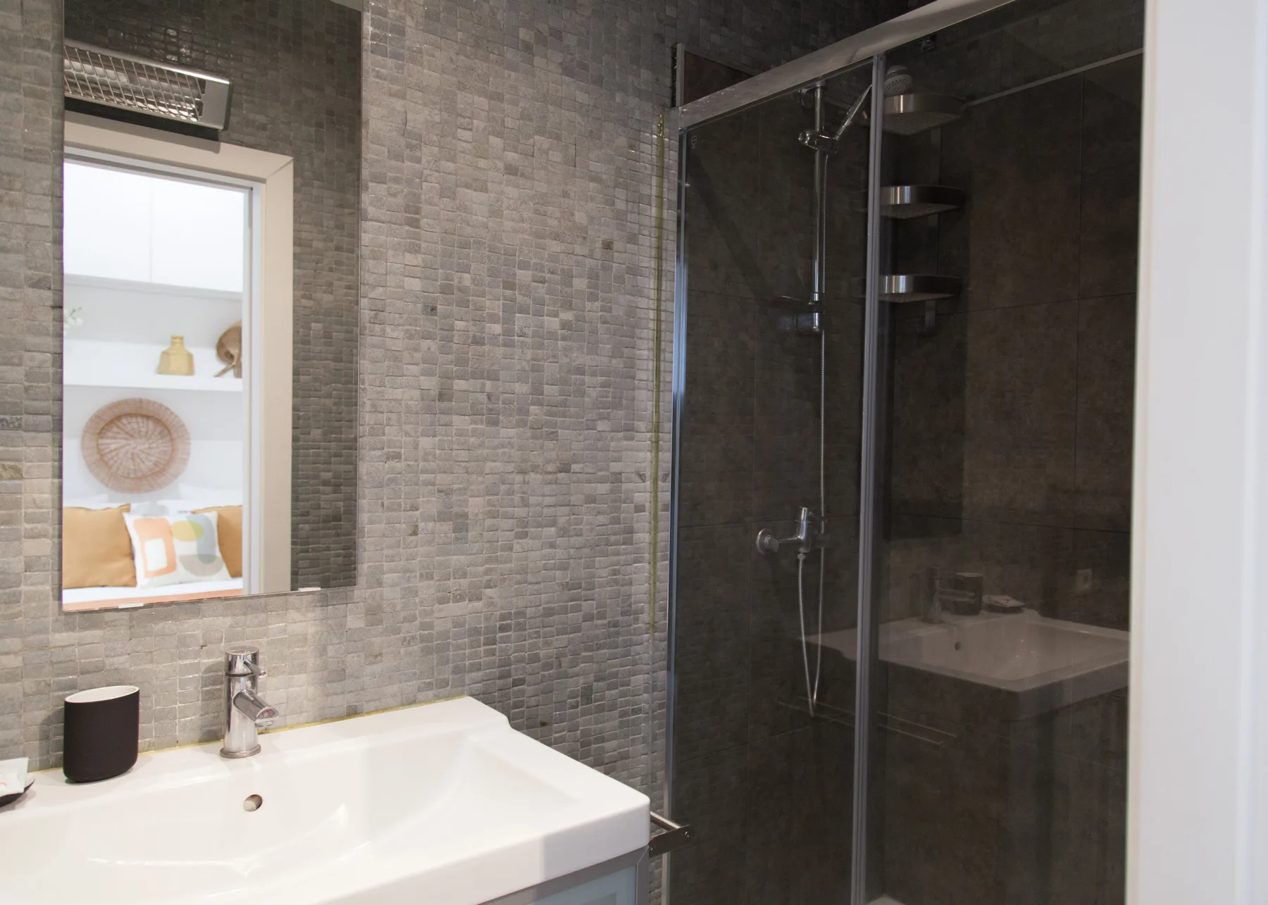 Un baño con lavabo y ducha de vidrio.