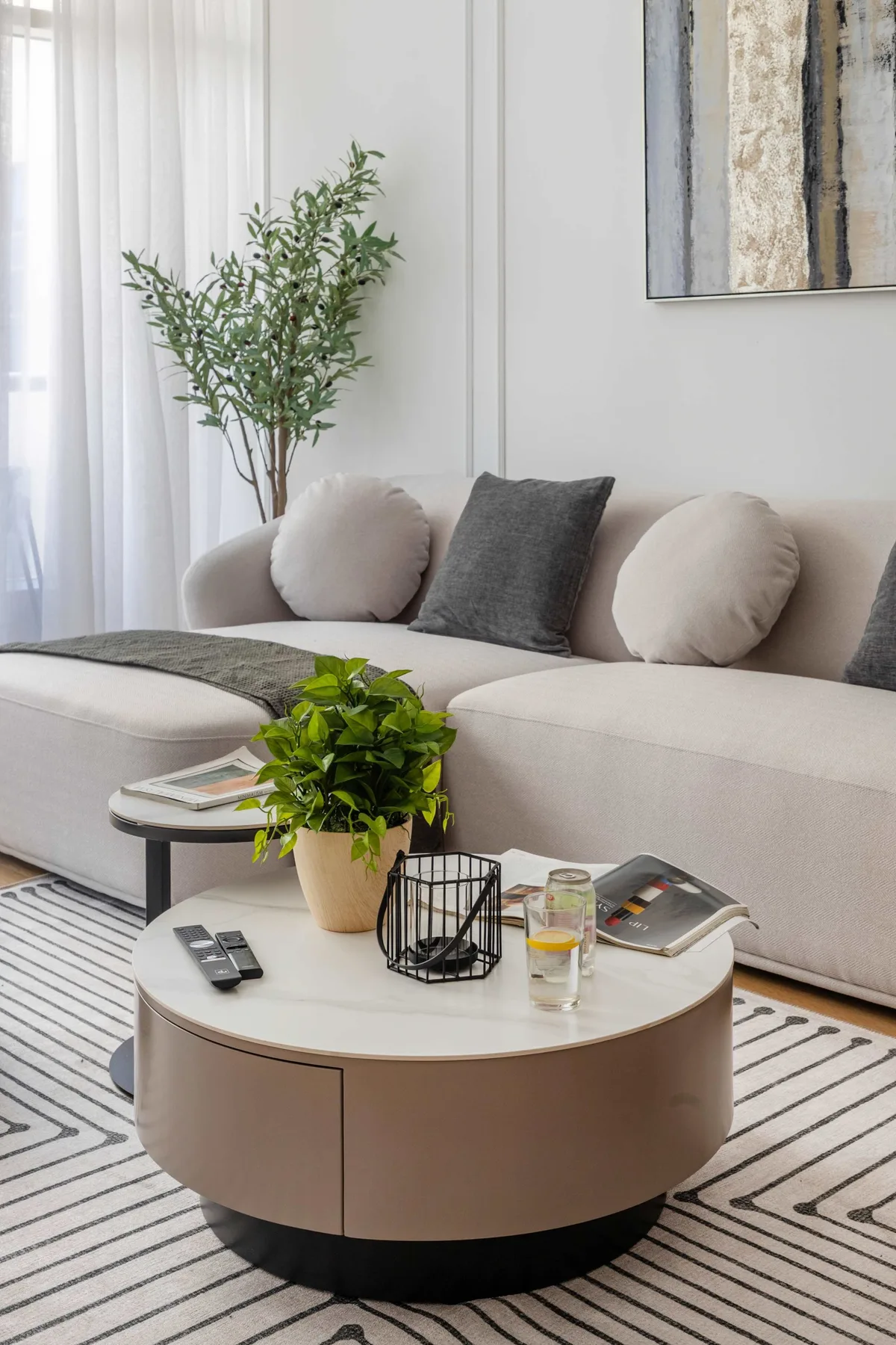 A bright living room with a light-colored sofa and round coffee table.