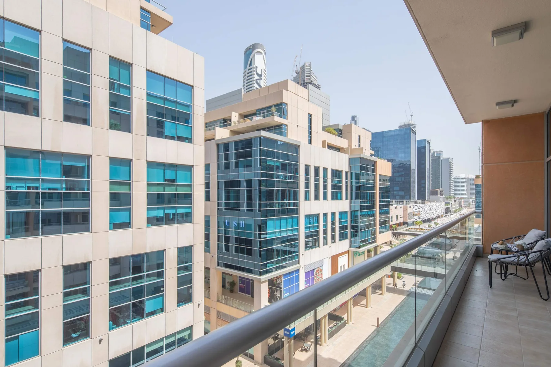 A balcony overlooks modern office buildings and a city street.