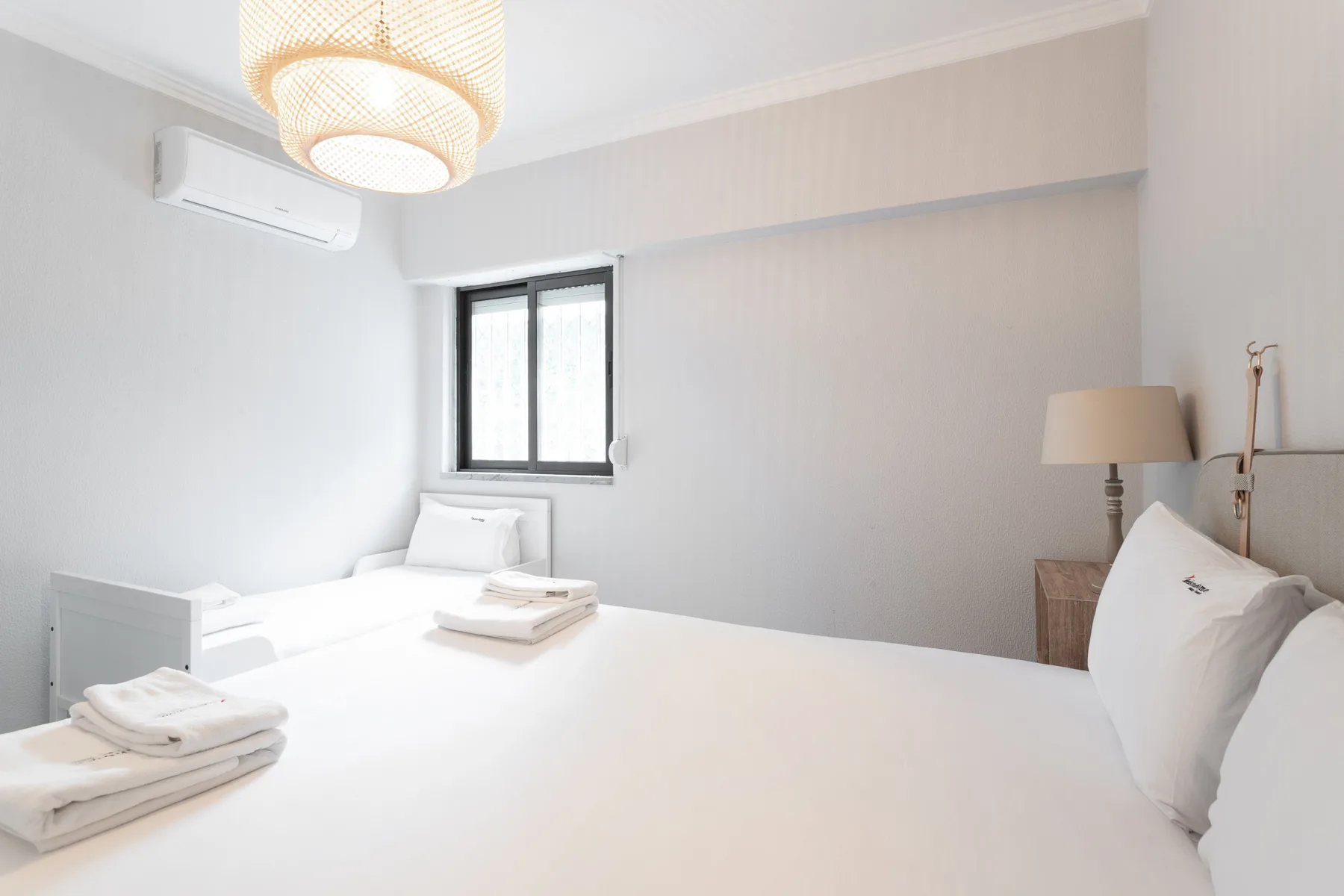 A bright bedroom with a large bed and a window.