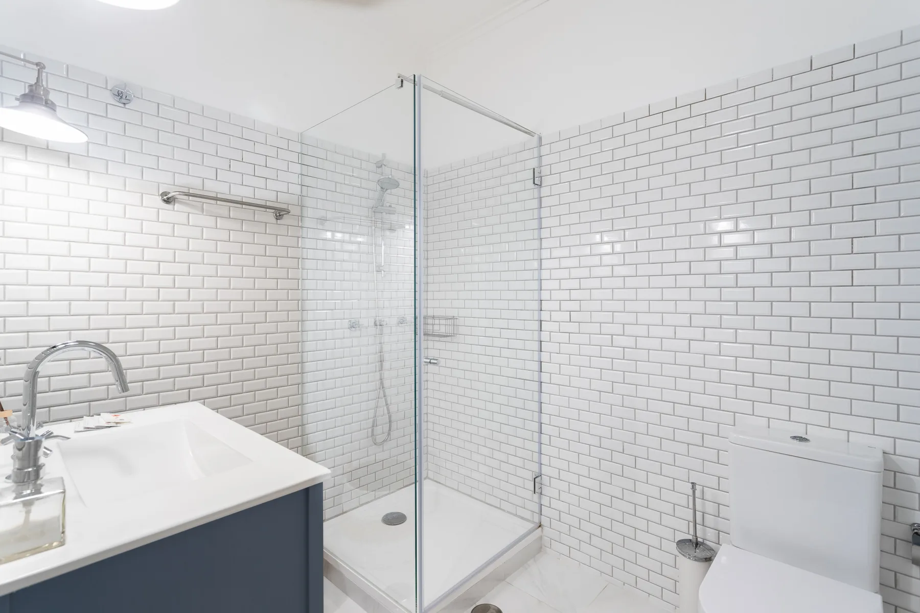 A tiled bathroom with a sink and a glass shower.