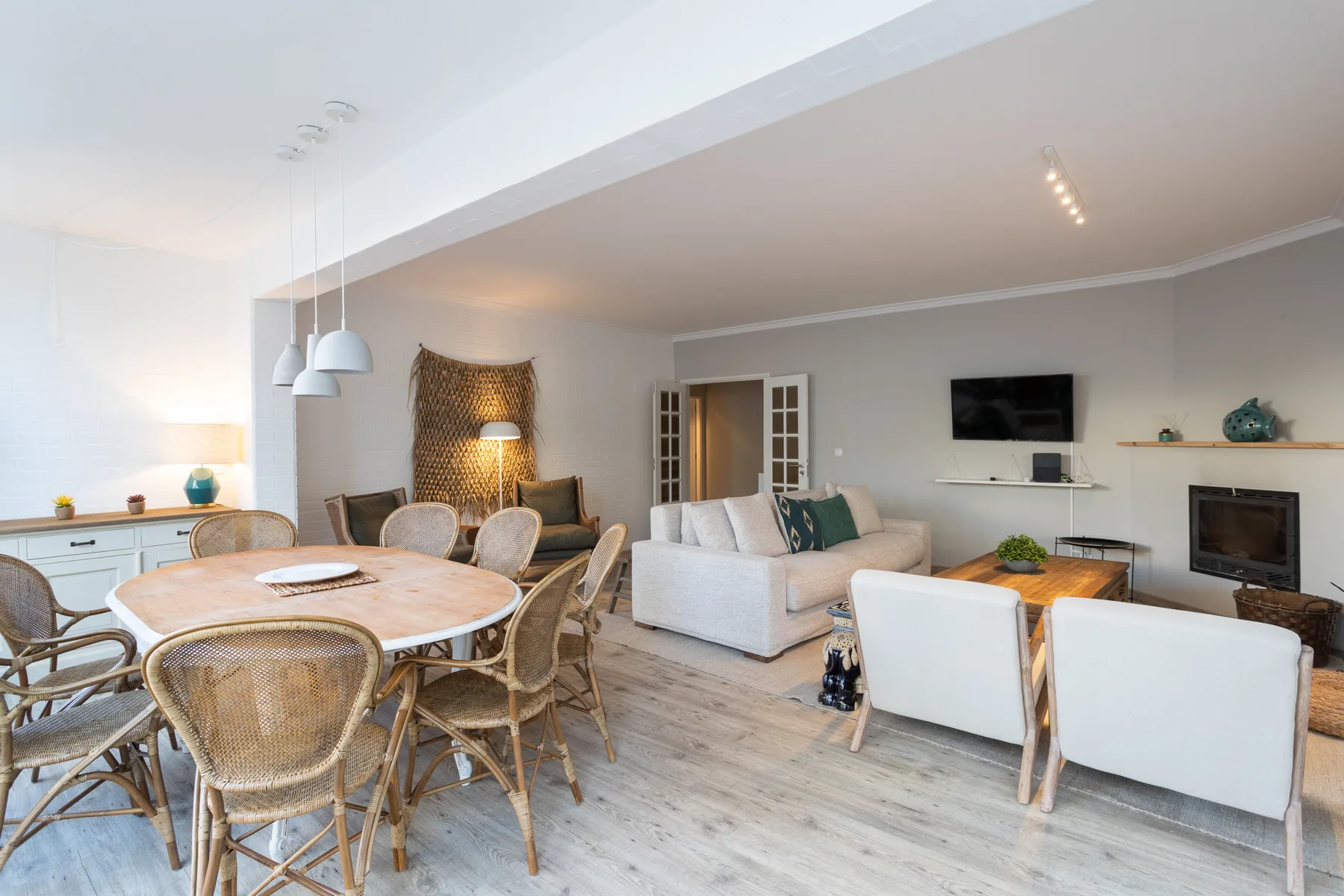 A bright living and dining area with a dining table and seating.