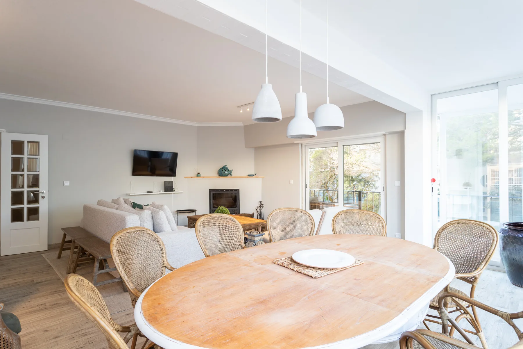 A bright open-plan living and dining area with a large wooden table and seating.