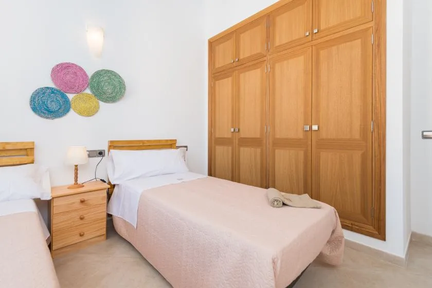 A bedroom with two beds and a large wooden wardrobe.