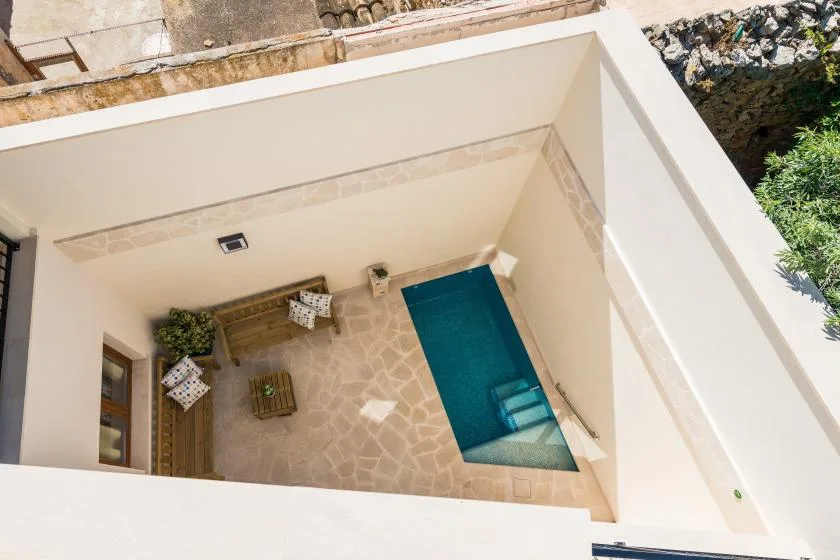 An enclosed patio with a small rectangular pool and outdoor seating.