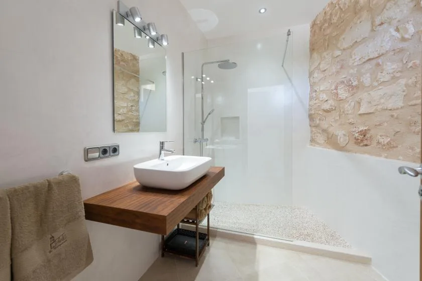 A bright bathroom with a white sink beside a glass shower.