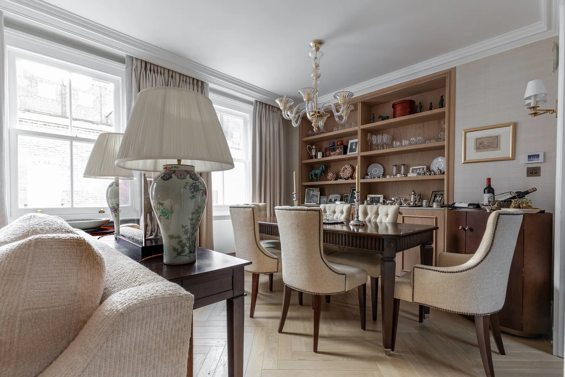A dining room with a table, upholstered seating, and built-in shelving.