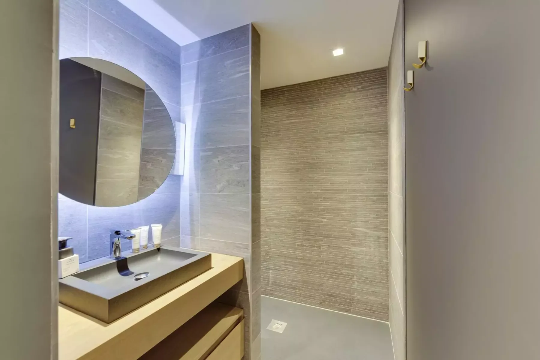 A modern bathroom with a wall-mounted mirror above the sink.
