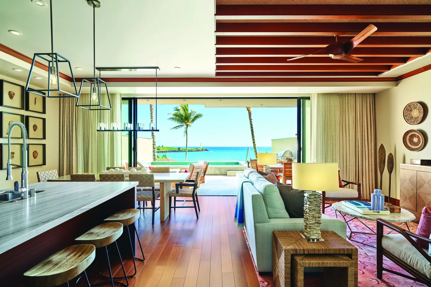 Una sala y comedor de concepto abierto dan a una luminosa vista de playa.