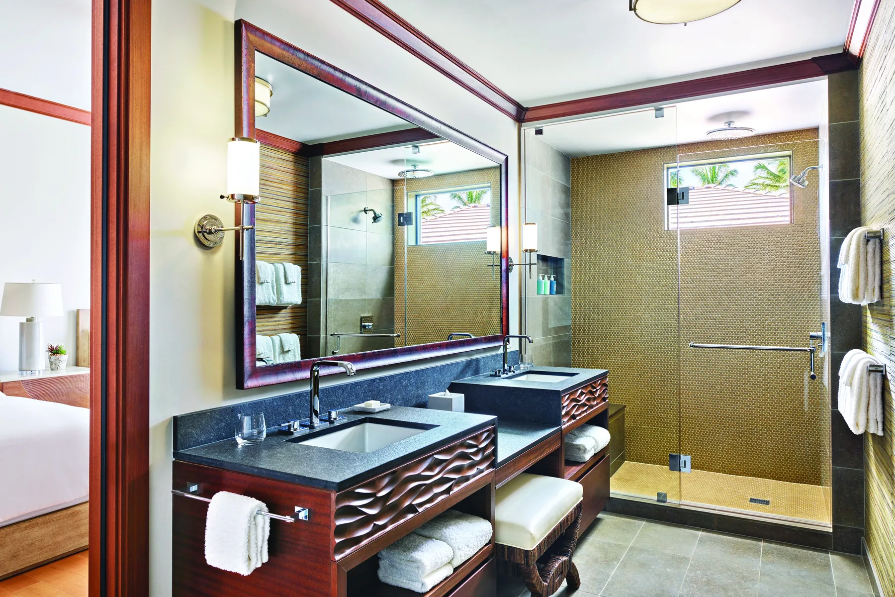 Un baño con un tocador doble, un espejo grande y una ducha de vidrio.