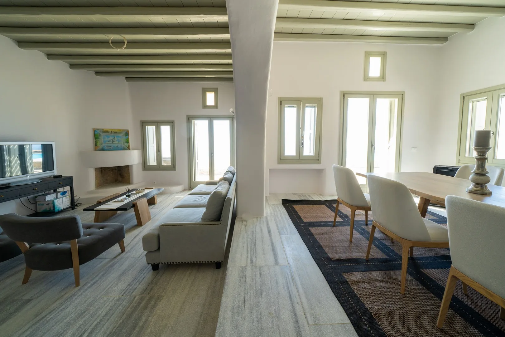 Sala de estar y comedor diáfanos con un sofá y una mesa de comedor.
