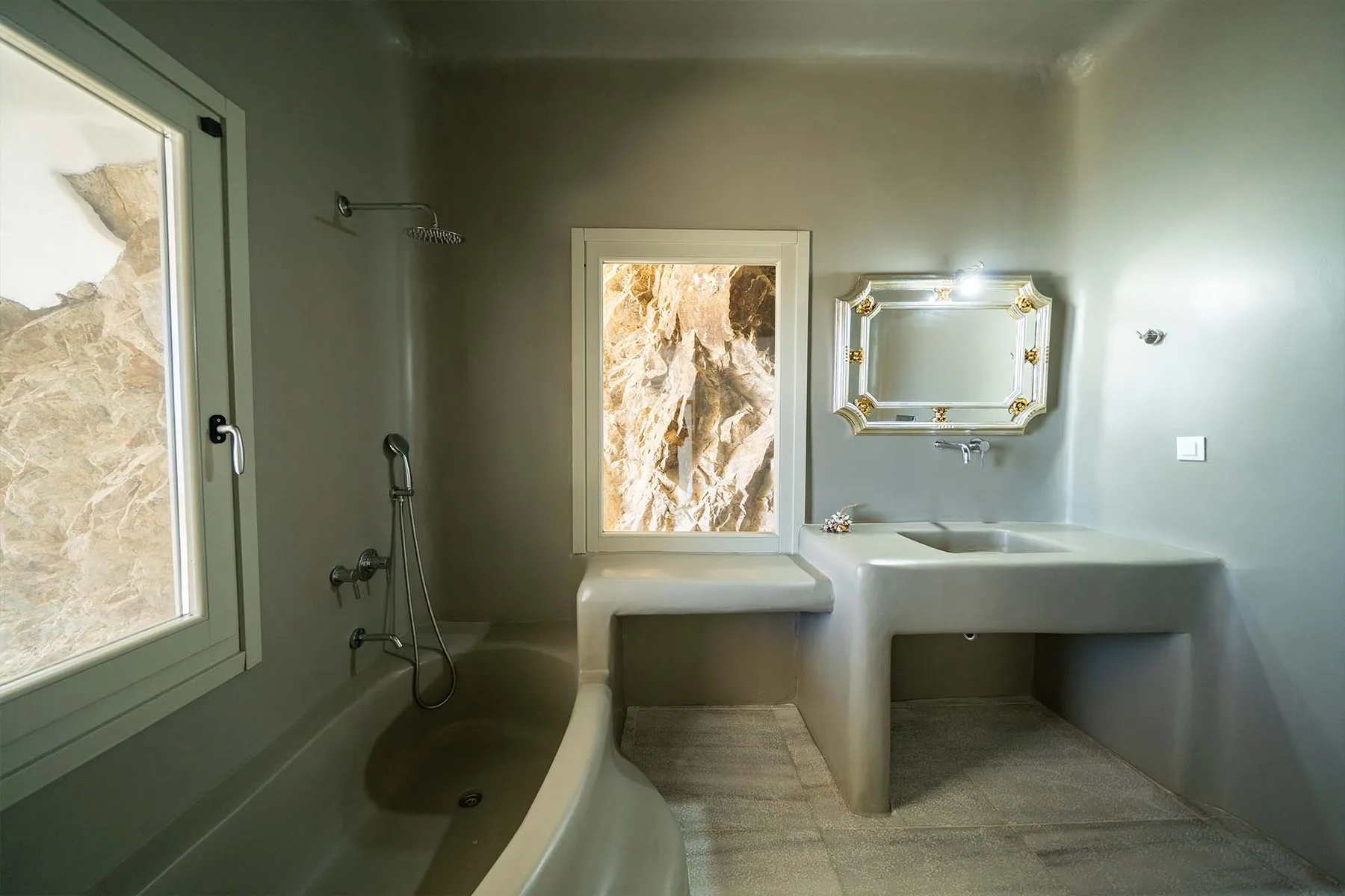 Un baño con bañera, grifería de ducha y un lavabo doble bajo un espejo.
