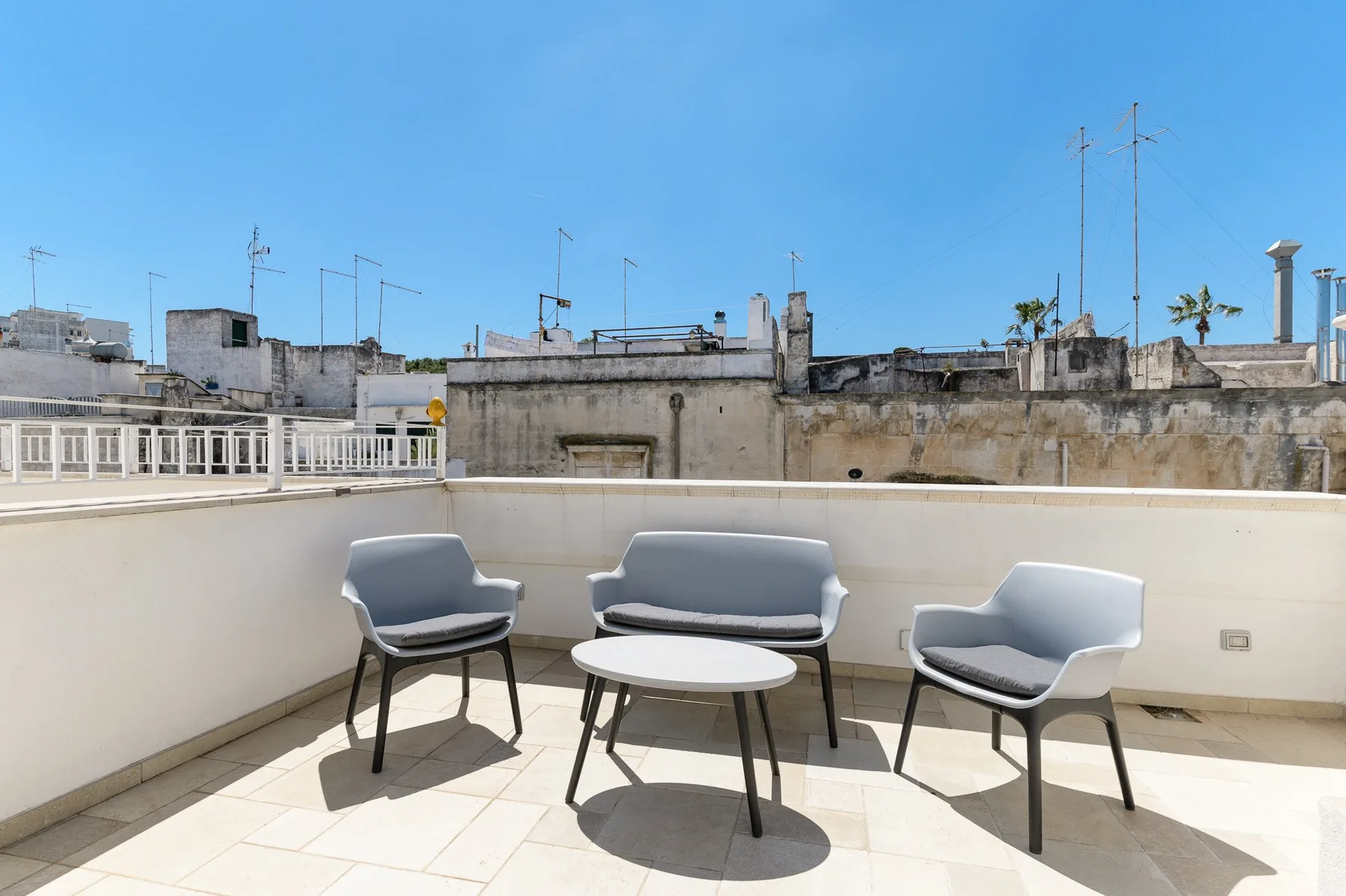 Una terraza en la azotea tiene asientos dispuestos alrededor de una mesa pequeña.