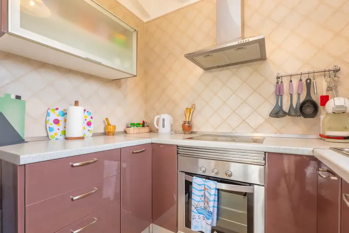 A kitchen with mauve cabinets, a countertop, and a built-in oven.