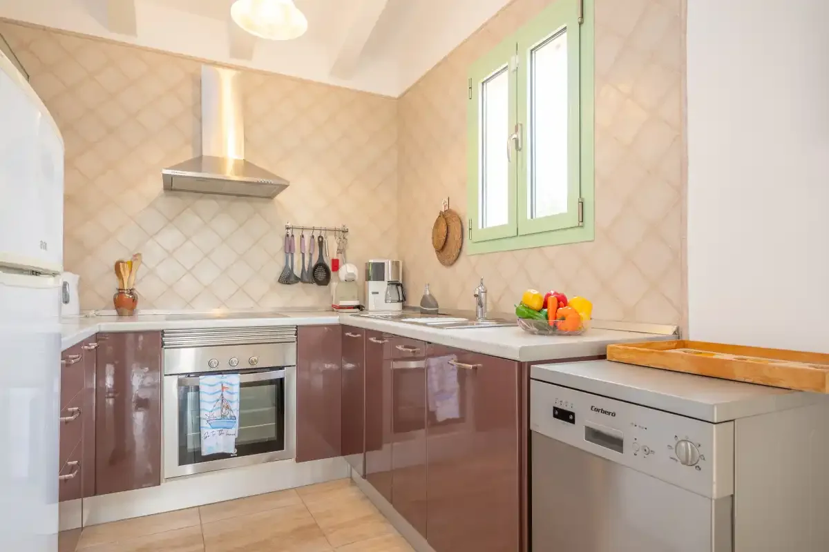 A bright kitchen with brown cabinets, a refrigerator, and a countertop.