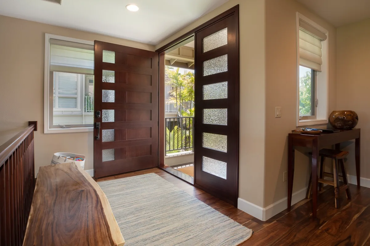 An entryway with open wooden doors and a view of a balcony.