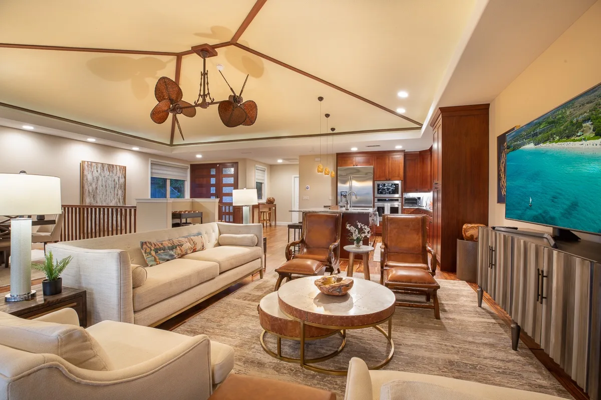 A spacious living room with seating, a dining table, and an open kitchen.