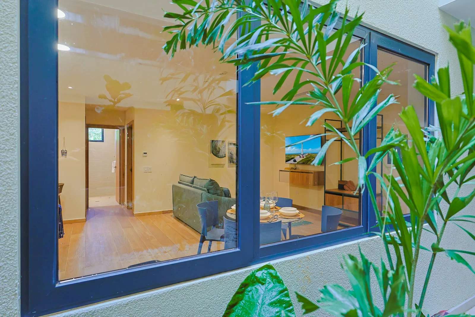 A view from the shared corridor reveals a stylish open living space and cozy dining nook, all wrapped in calm neutral tones and filled with welcoming natural light.
