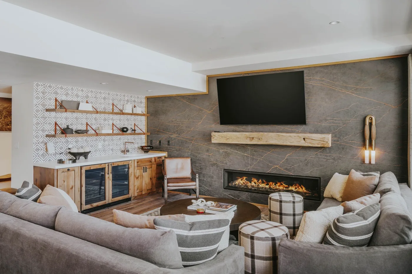 A living room with a sectional seating area, fireplace, and wall-mounted television.