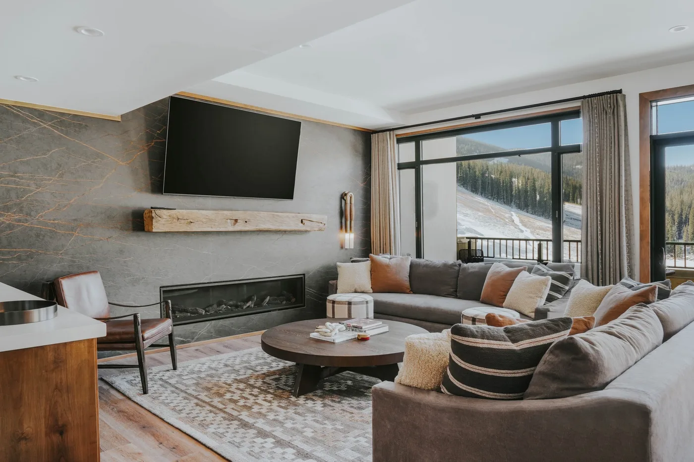 A living room with seating arranged around a coffee table and fireplace.