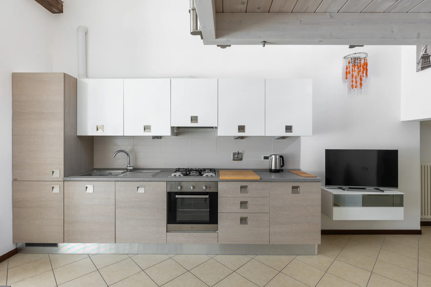Una cocina moderna con muebles claros, una placa de cocción y un horno.
