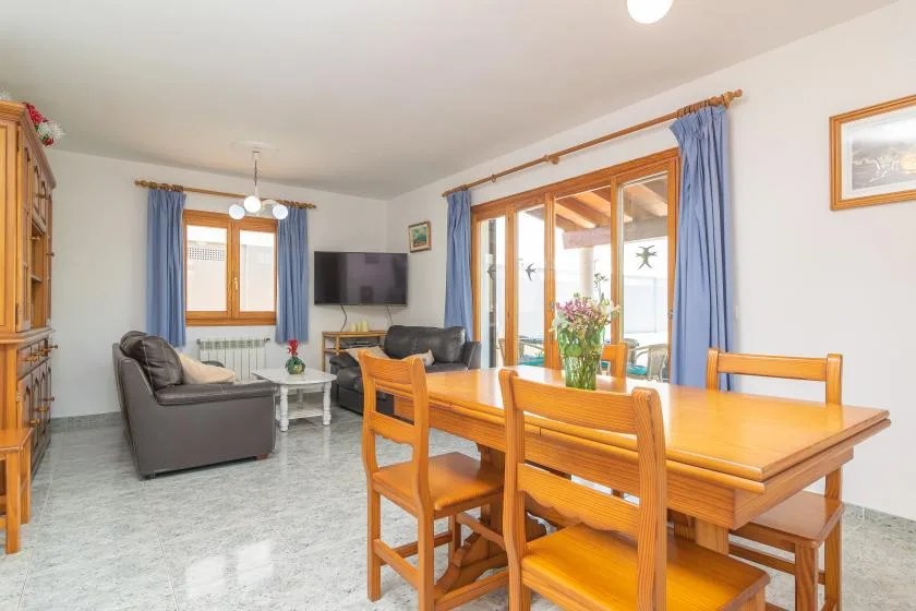 A living and dining room with wooden seating and blue curtains.