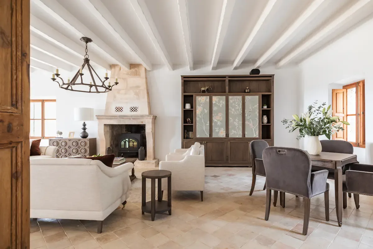 A bright living and dining room with a fireplace and dark wood cabinetry.