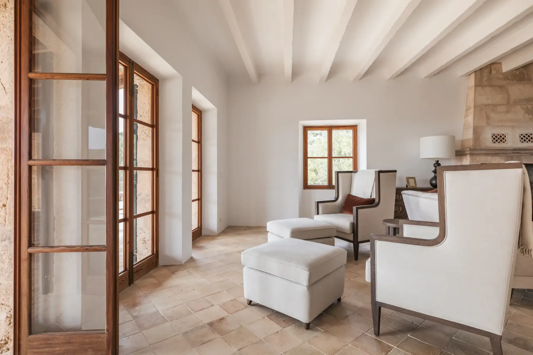 A bright sitting area with cushioned seating and exposed ceiling beams.