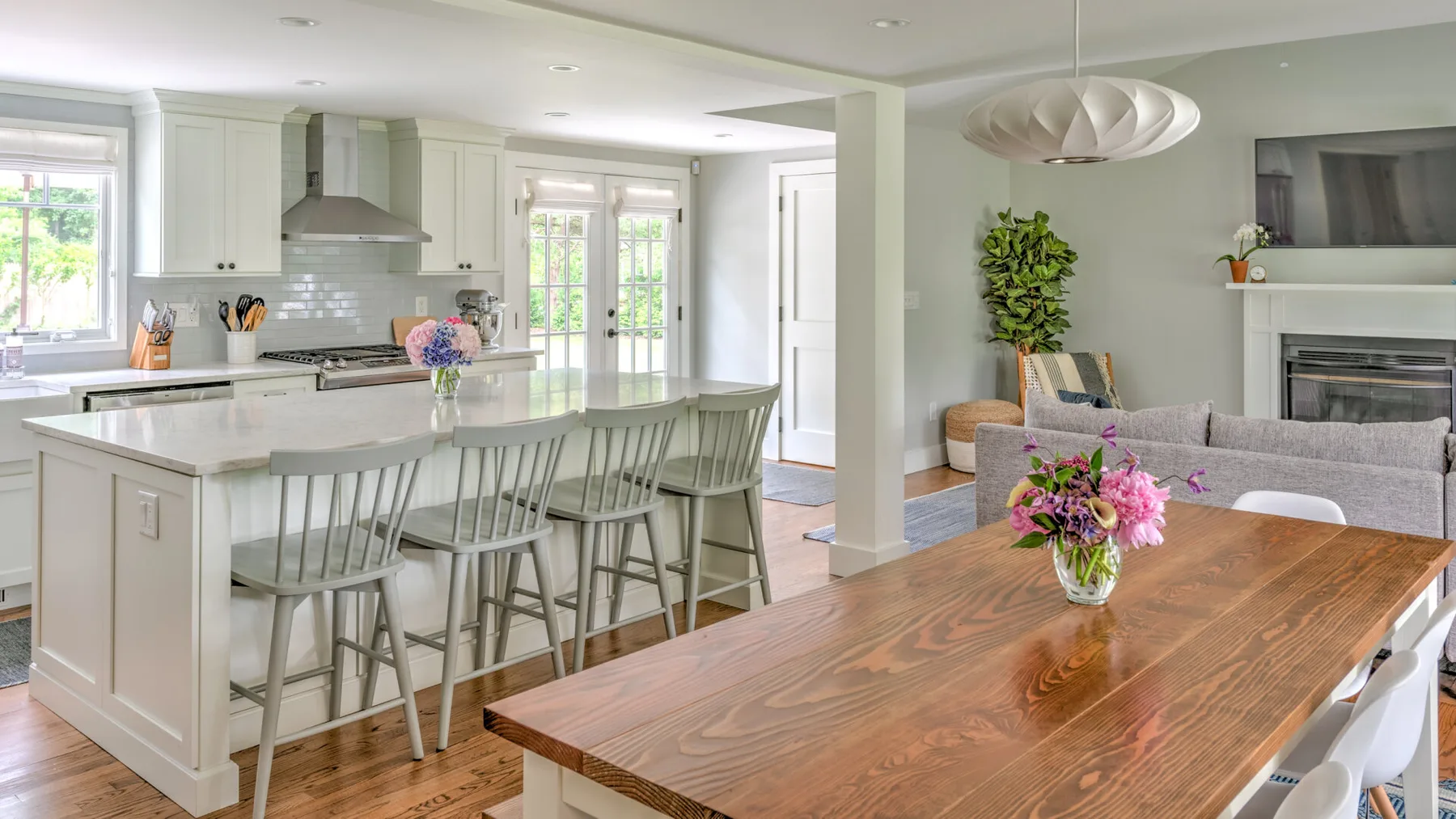 A bright open-plan kitchen and dining area with a large island and wooden table.
