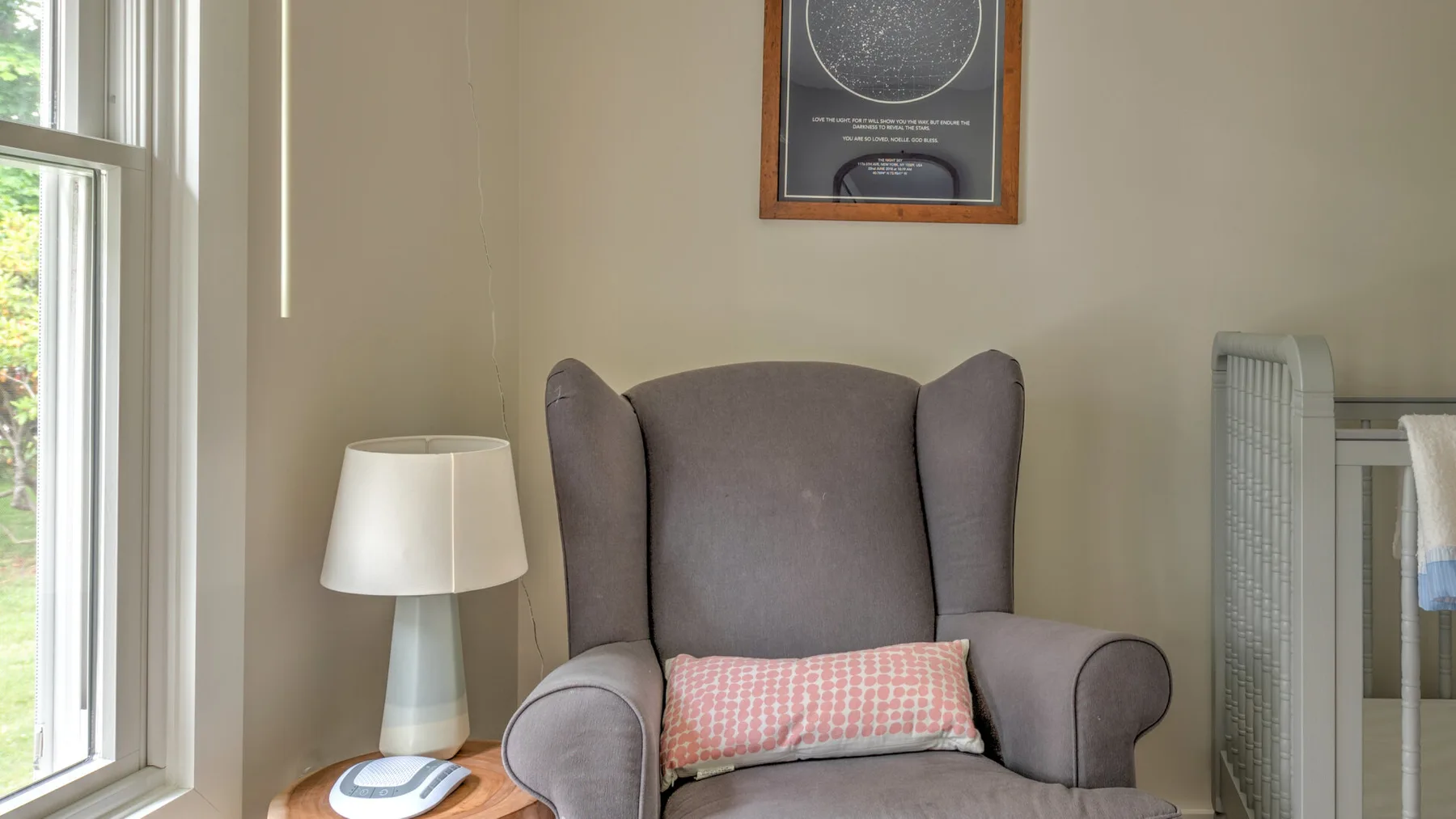A sitting area with a wingback chair beside a tall window.