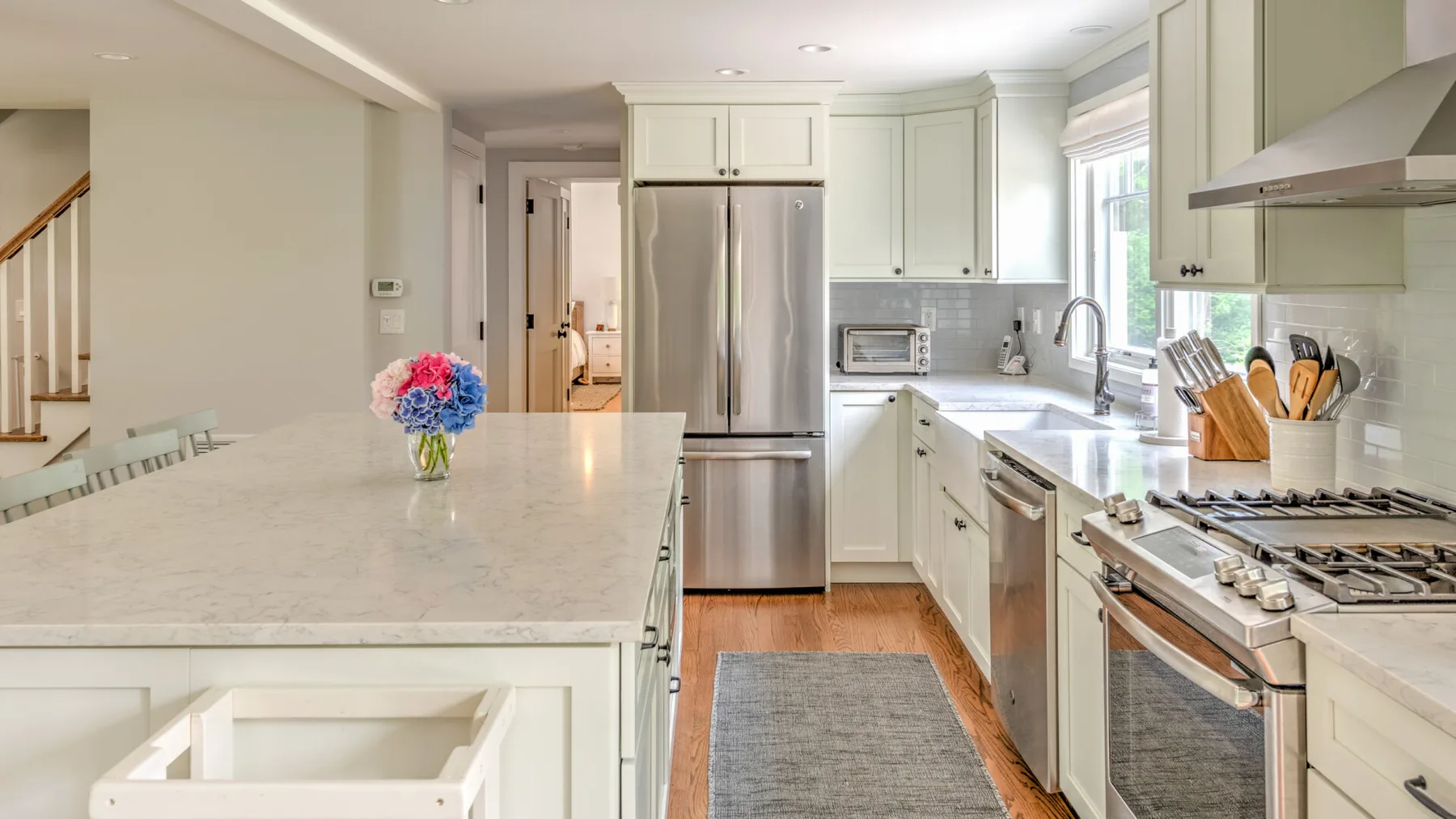 A bright kitchen with a large island and stainless steel appliances.