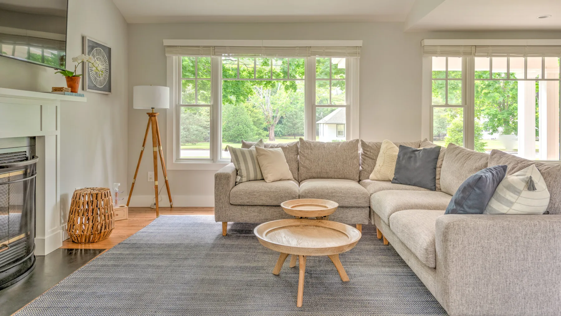 A bright living room with a sectional seating area and large windows.