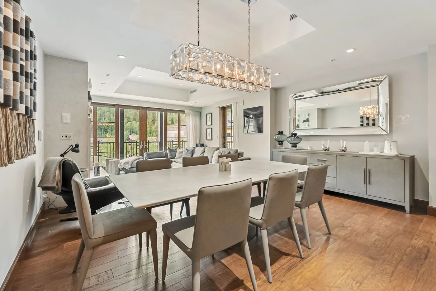 A bright dining area with a long table and seating beside large windows.
