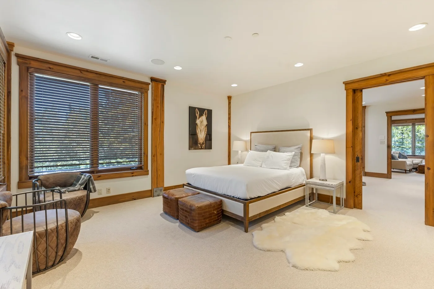 A bedroom with a bed, bedside tables, and a window with blinds.