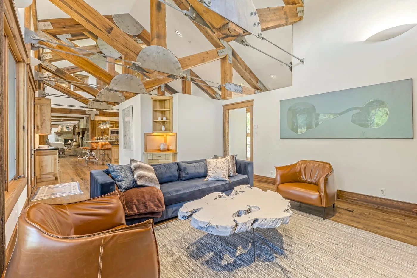 A living room with a blue sofa, leather seating, and a round coffee table.