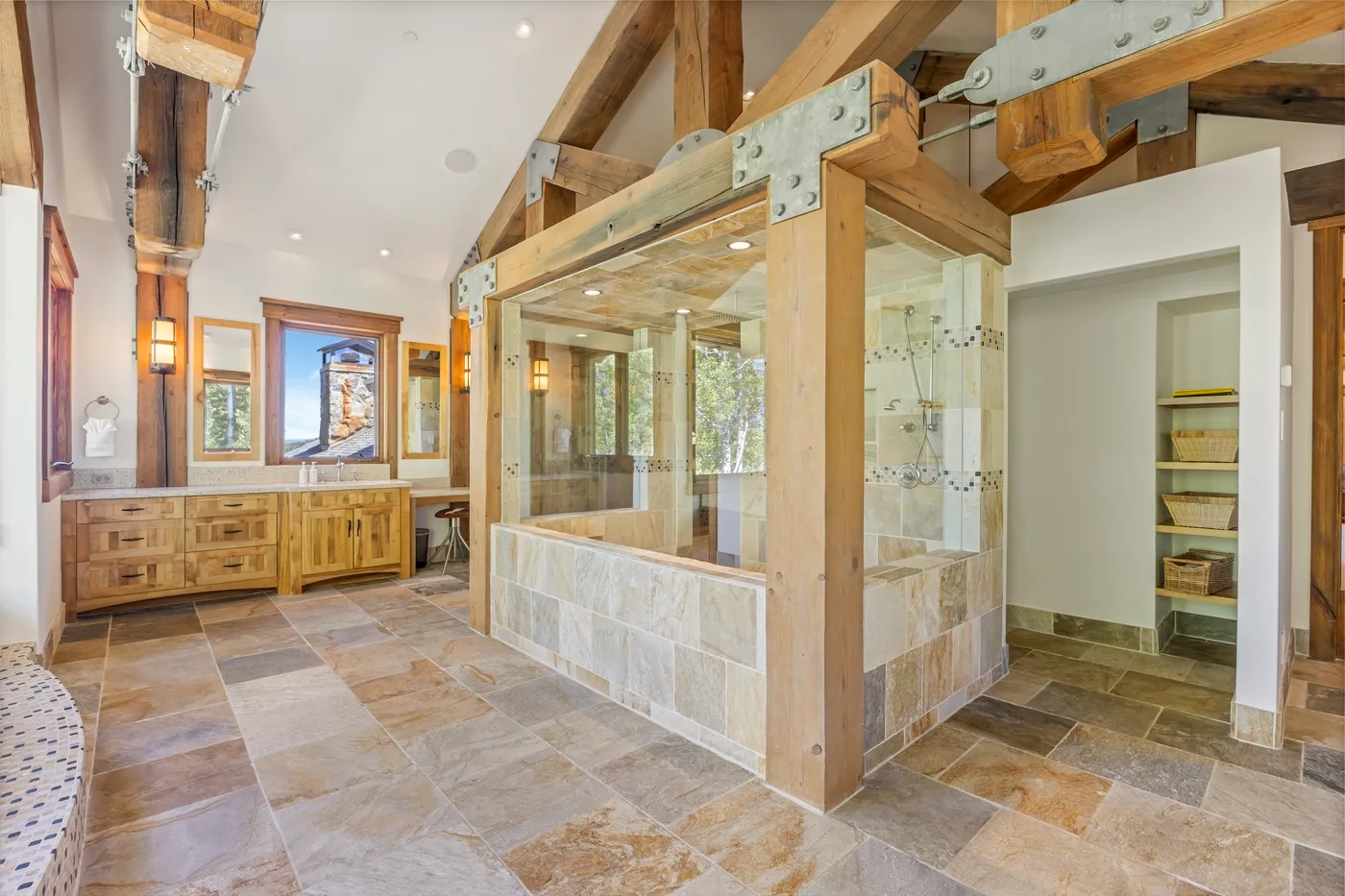 A spacious bathroom with a tiled shower area and wooden beams.