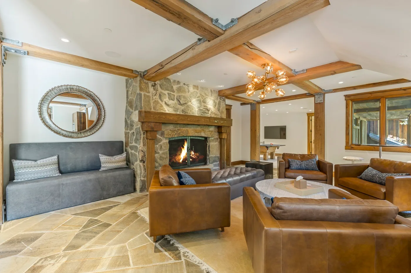 A living room with seating arranged around a fireplace and coffee table.