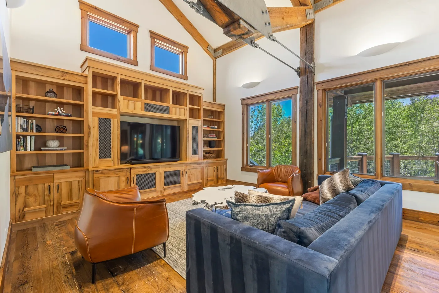 A living room with a television, built-in wooden shelving, and seating.