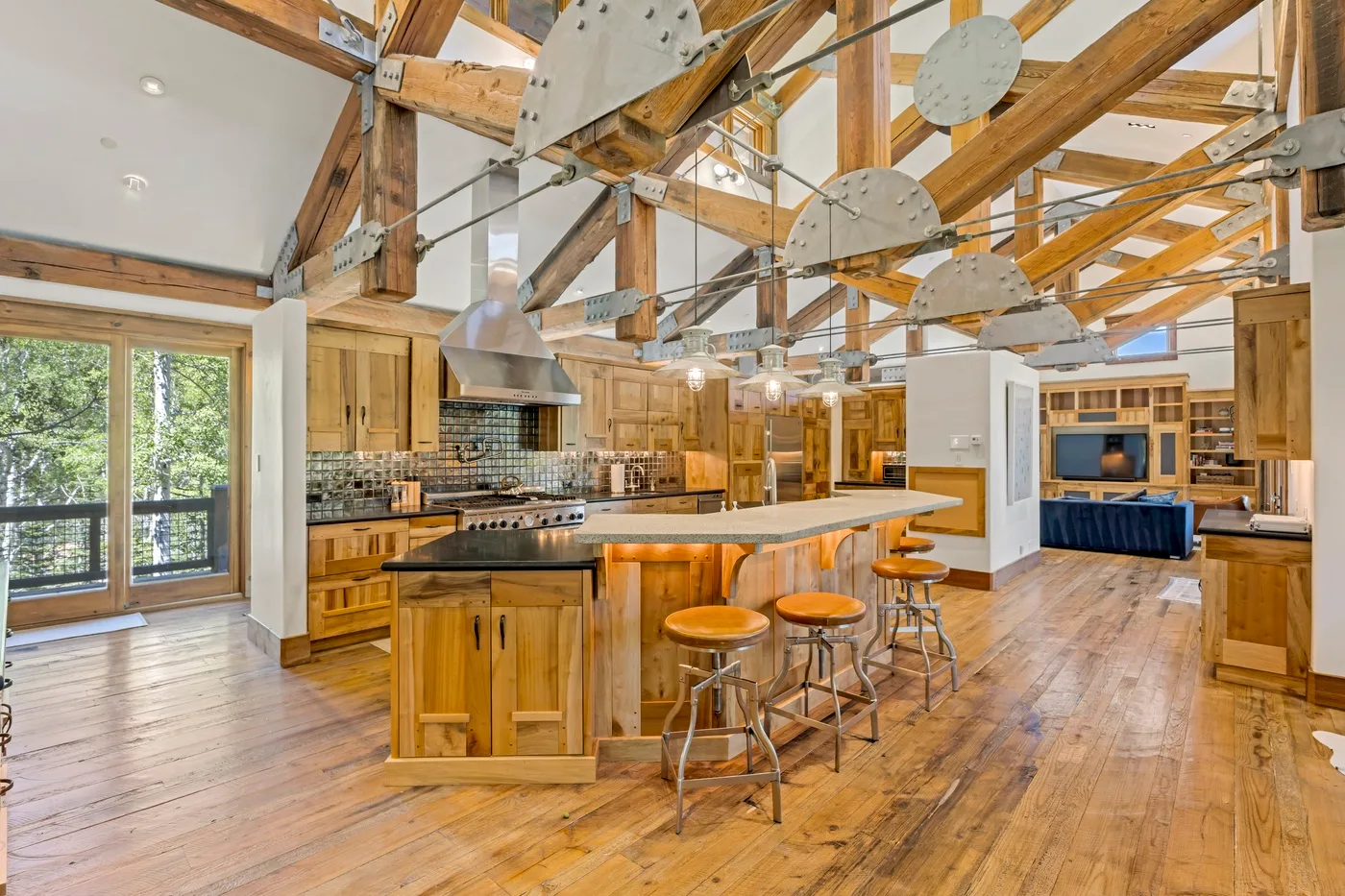 A spacious kitchen with a central island and exposed wooden beams.