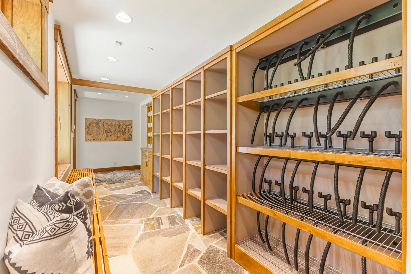 A storage room with wooden shelving and racks of black equipment.