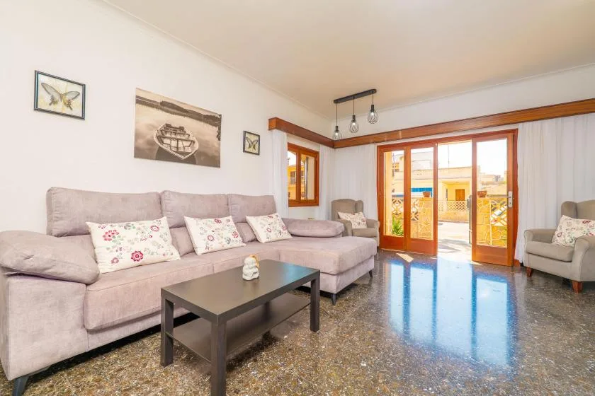 A living room with seating, a coffee table, and glass doors opening onto a balcony.