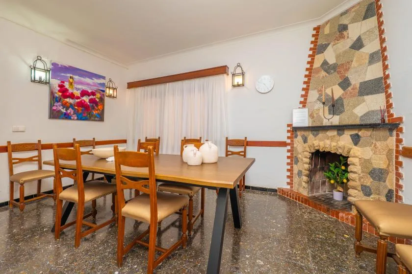 A dining area with wooden seating and a stone fireplace.