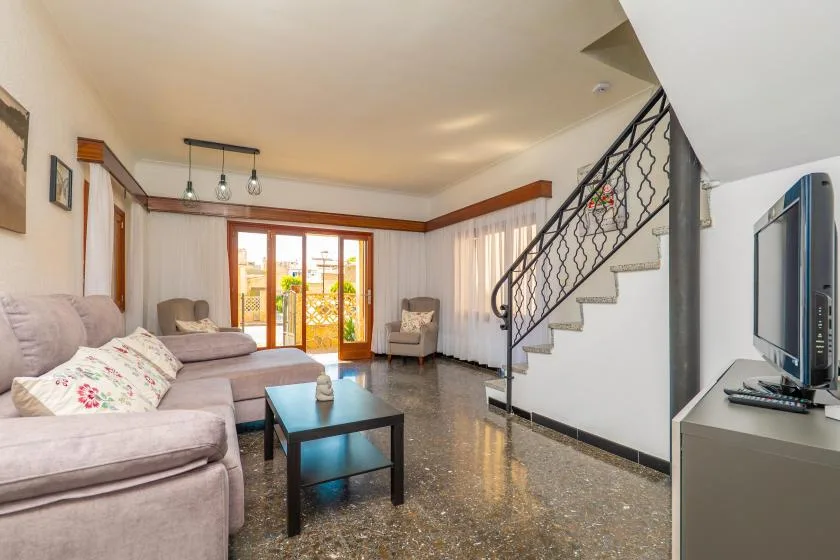 A living room with seating, a coffee table, and a staircase.