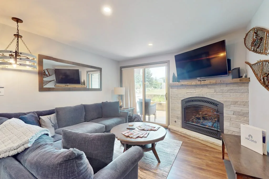 A living room with seating arranged around a coffee table and fireplace.