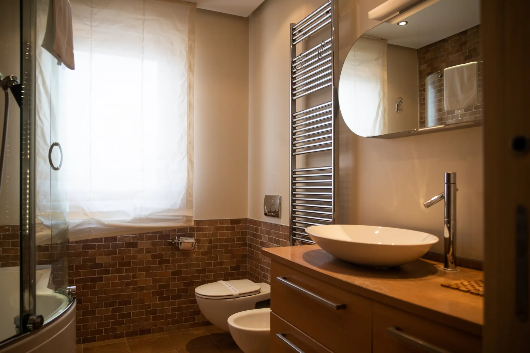 A bathroom with a sink and toilet beside a glass shower.