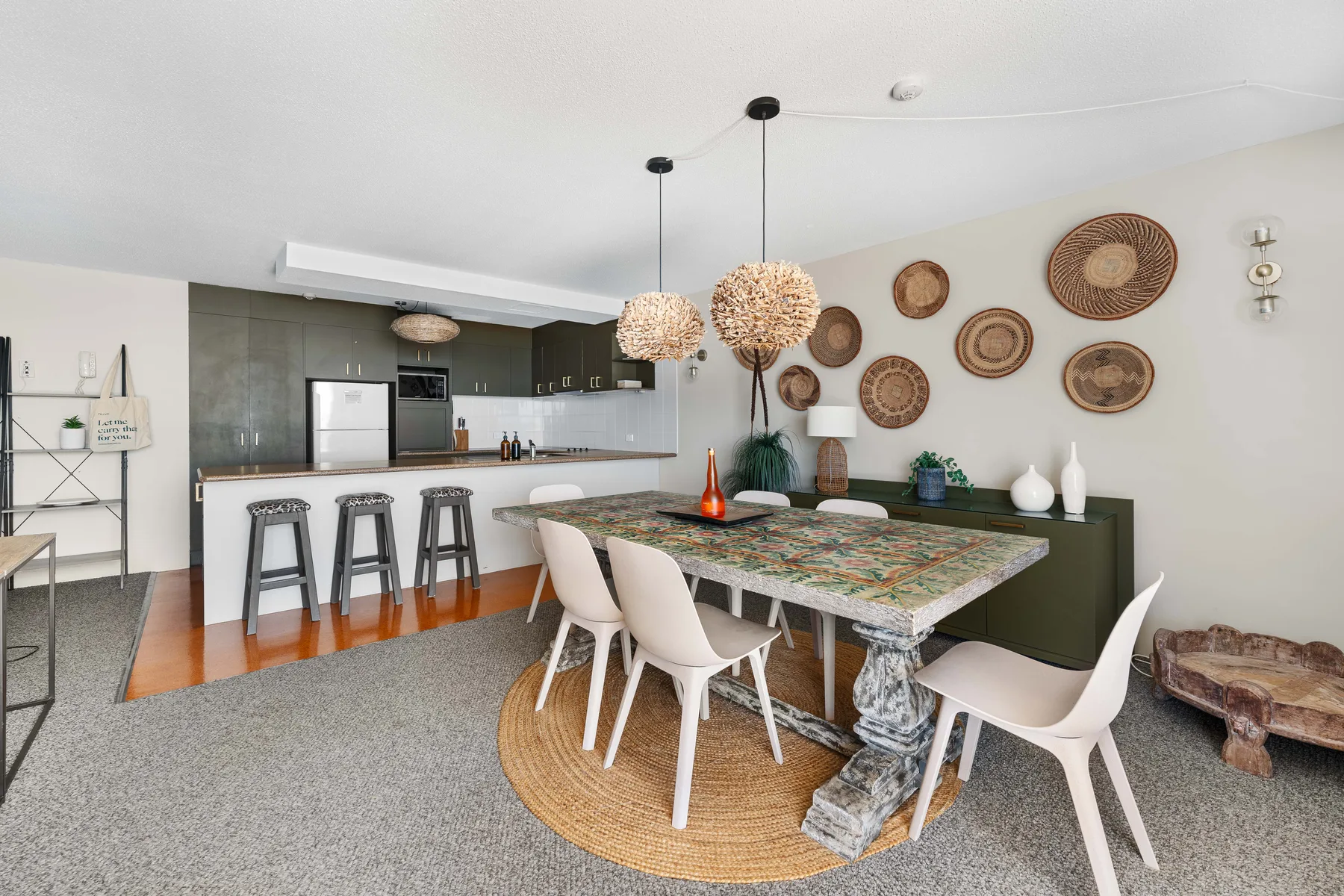 An open-plan dining area with a long table beside the kitchen.